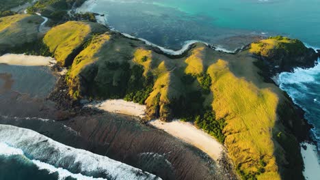 aerial shot over lombok island with famous bukit merese hills and sandy beaches with crashing waves from the ocean. lombok,indonesia.