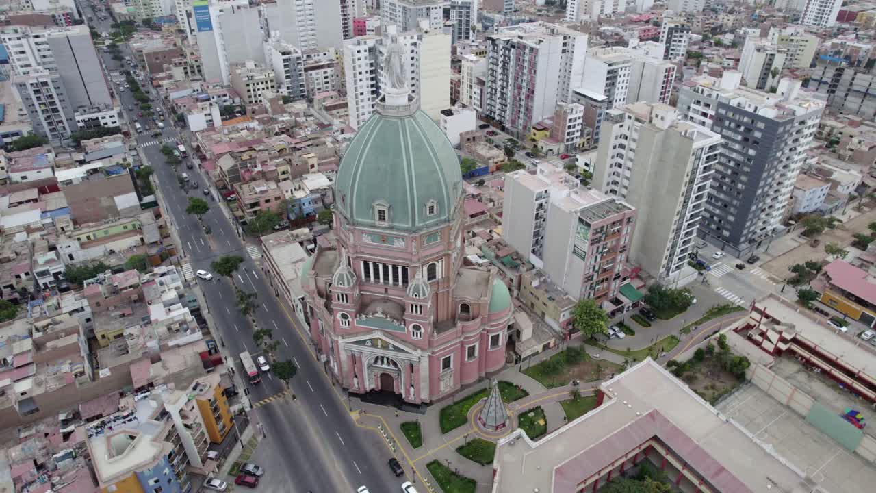 Veduta aerea di una maestosa chiesa con cupola verde in una città vivace.