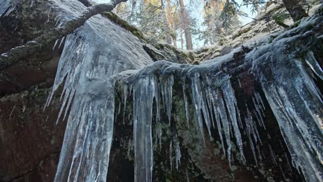 carámbano enorme sobre una montaña rocosa en el bosque de invierno