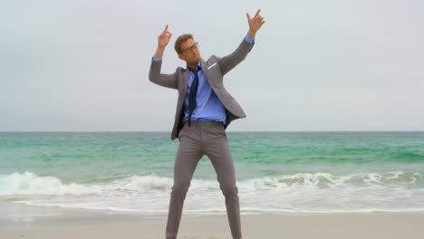 vista frontal de un hombre de negocios caucásico bailando en la playa 4k