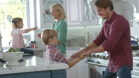 Familia-Jugando-Juegos-En-La-Cocina-Moderna,-Cámara-Lenta