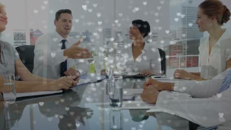 Animation-of-hearts-and-cityscape-over-diverse-business-people-in-office