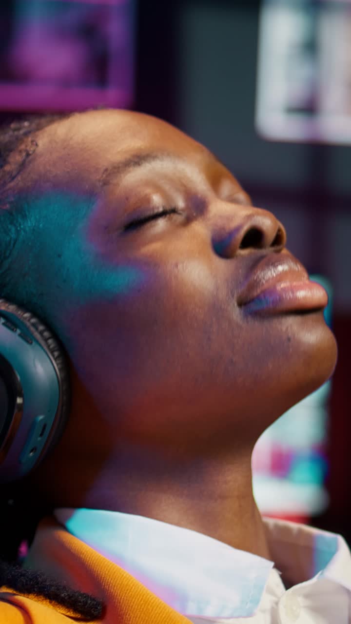 Video verticale. Una studentessa spensierata termina di creare una presentazione e si rilassa con la musica