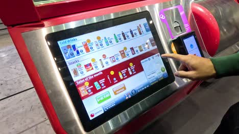 person interacts with a touchscreen vending machine