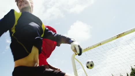 two football players jumping to strike a ball