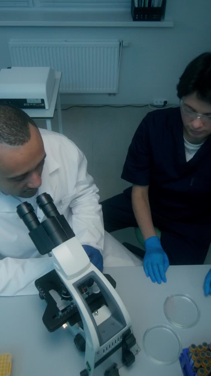 científicos que trabajan con el microscopio en un laboratorio