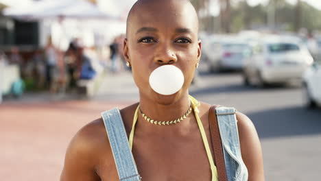 mujer negra, cara y soplando burbuja con chicle