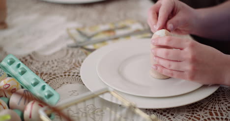 woman peeling egg on plate