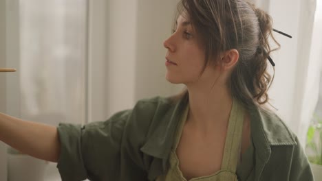 mujer pintando en un estudio de arte