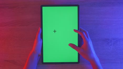 tableta con pantalla verde y manos