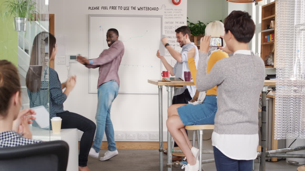 Crazy happy african american businessman dancing doing victory dance in team meeting celebrating success achievement