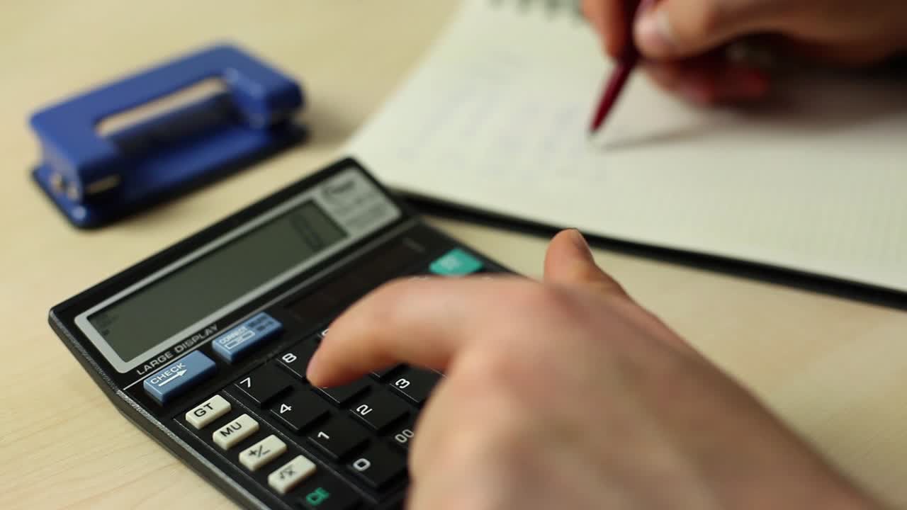 hombre de negocios trabajando con un libro y usando una calculadora