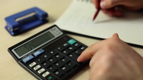 hombre de negocios trabajando con un libro y usando una calculadora