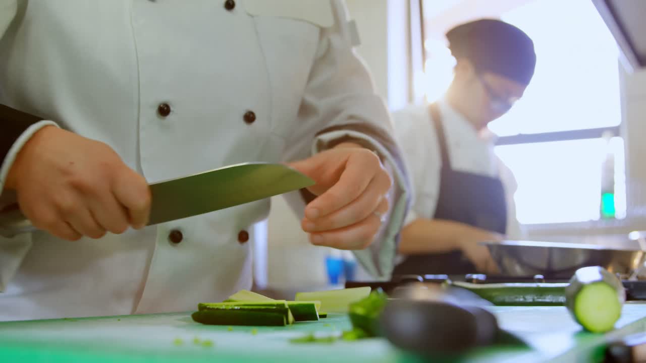 chef cortando verduras en la cocina en el restaurante 4k