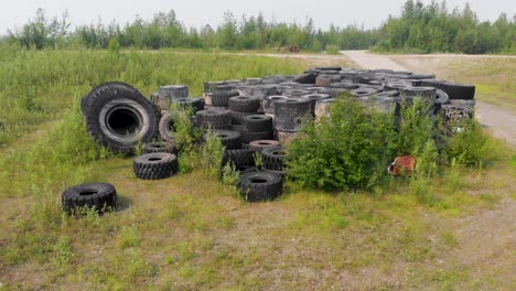 video de drones de 4k de una pila de neumáticos de excavadoras gigantes desechados en el desierto cerca de fairbanks, ak durante el día de verano-9