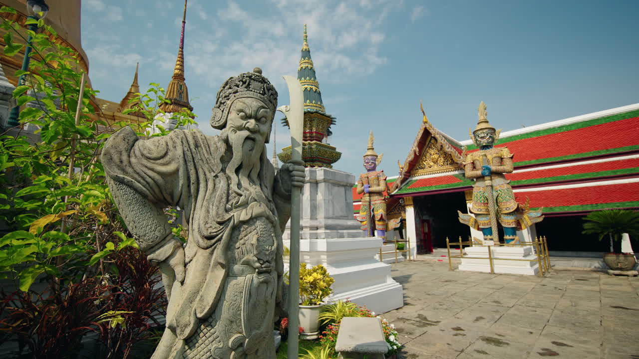 Estatua de guerrero guardián de piedra en Wat Phra Kaew en Bangkok con colorida arquitectura del templo y demonios gigantes en Tailandia