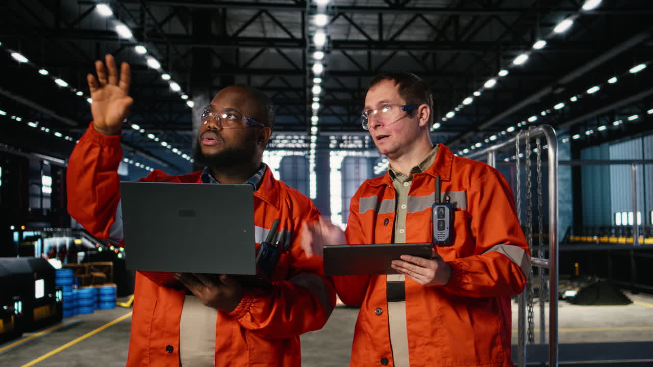 Colleagues use laptop and tablet to guide personnel during fabrication