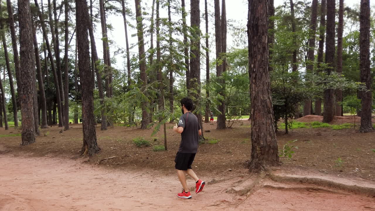 hombre caucásico corriendo por el sendero del bosque