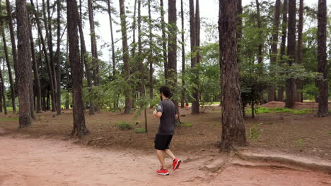 caucasian man running on the forest trail