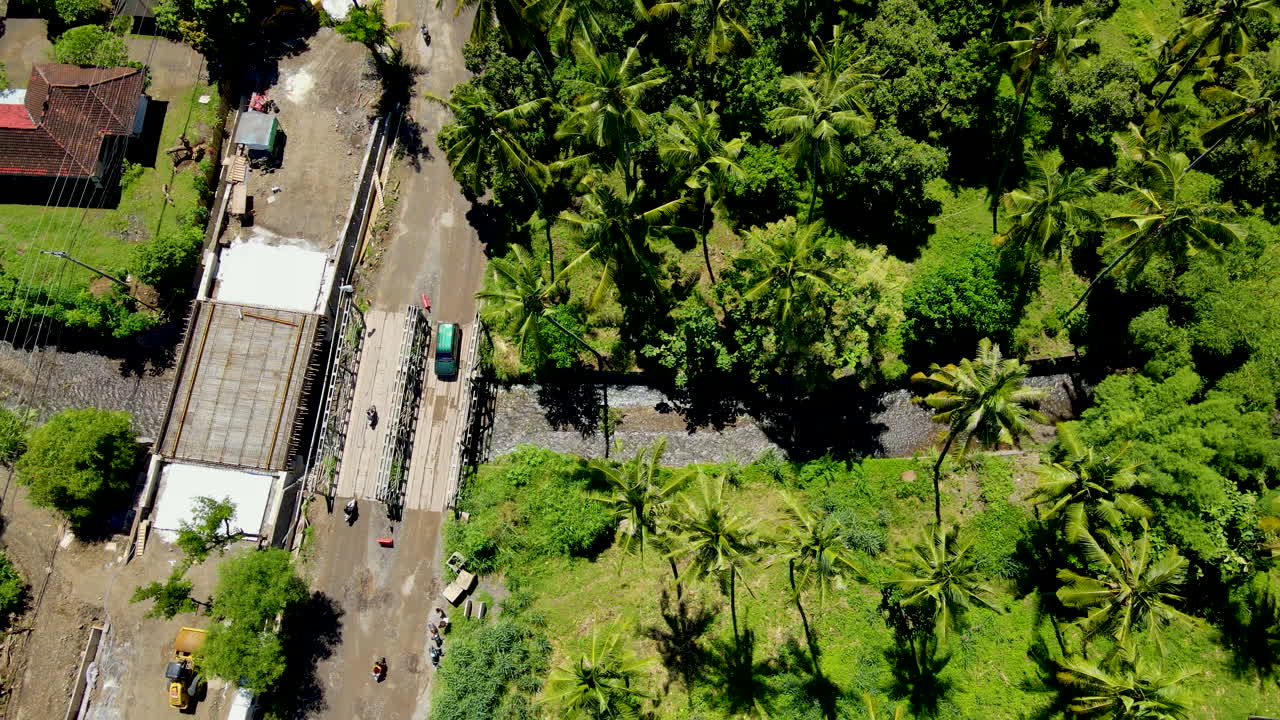 campo de verano con autos cruzando el puente sobre el río en el bosque tropical en el oeste de bali, indonesia