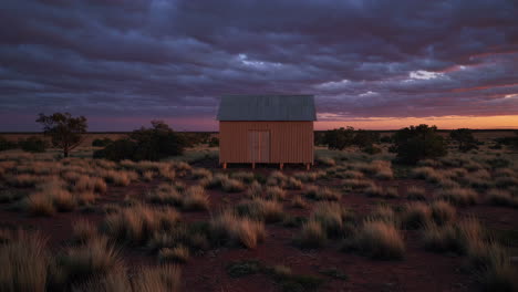solitary hut in arid landscape at sunset
