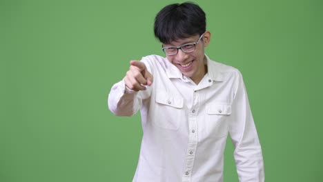 happy young asian businessman laughing while pointing finger