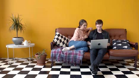 couple working on laptop on couch