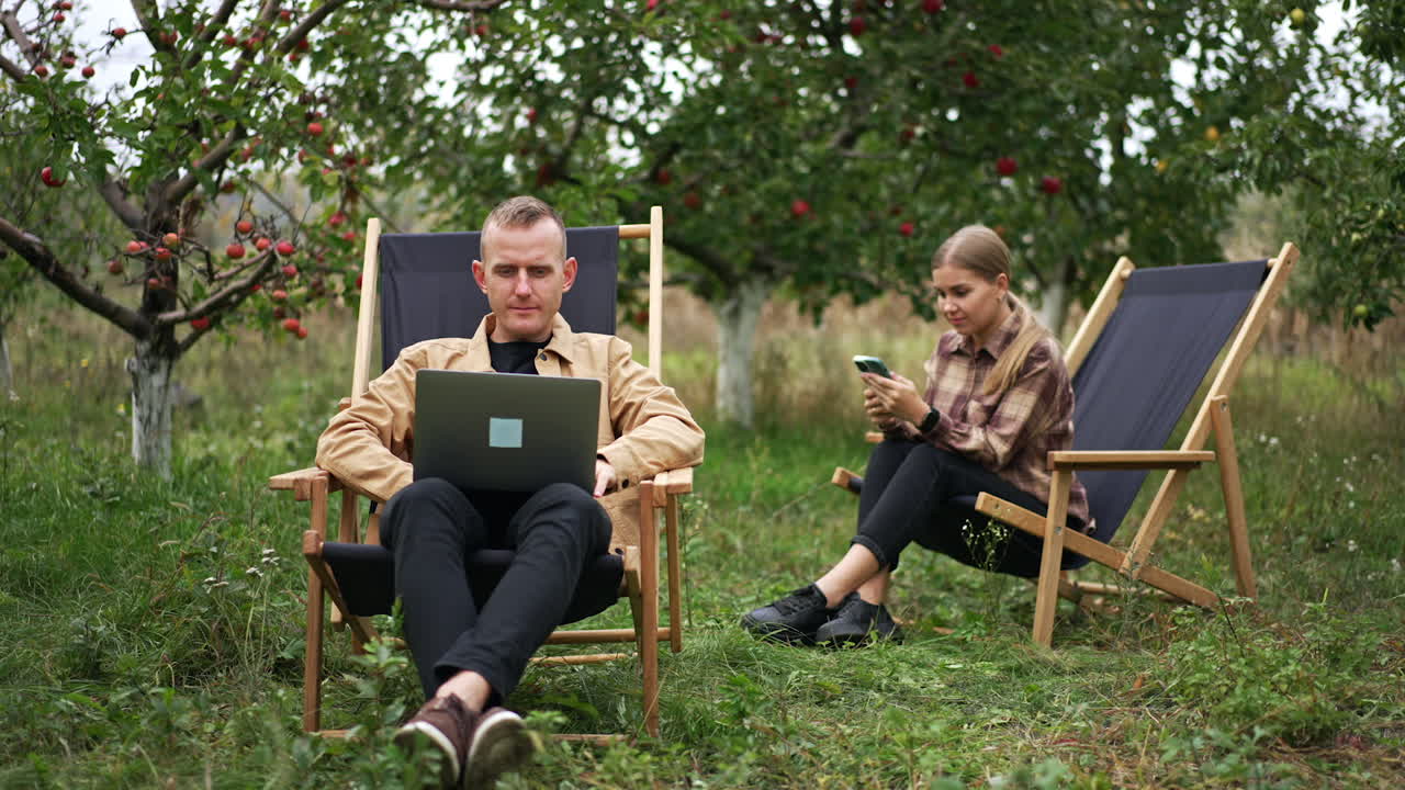 Couple Working Outdoors in an Apple Orchard
