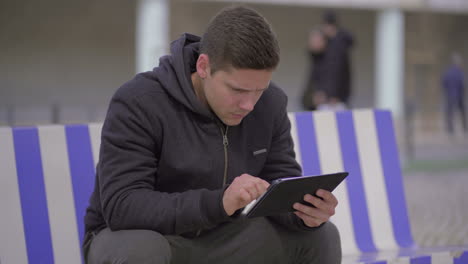 Serious-man-using-digital-tablet-on-street