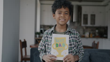 young boy holding homemade fathers day card