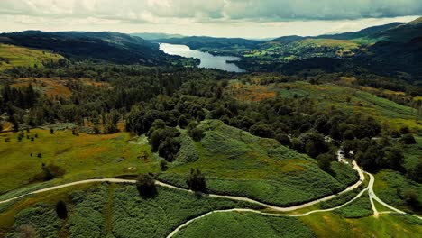 ariel video footage of clouds rolling over mountains and hills with trees in lake district, cumbria, uk