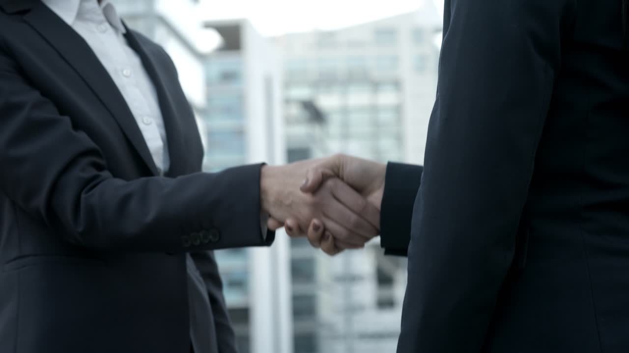 Cropped shot of businesswomen shaking hands on street