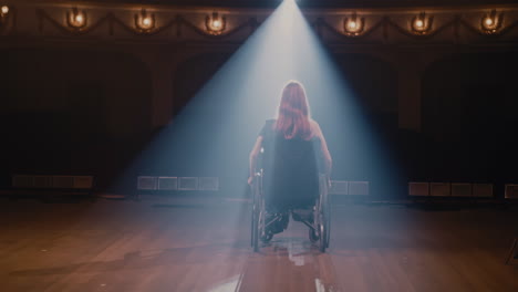 handicapped actress talking passionately on stage anonymous woman on wheelchair riding on stage then starting to speak passionately with audience during performance in theater