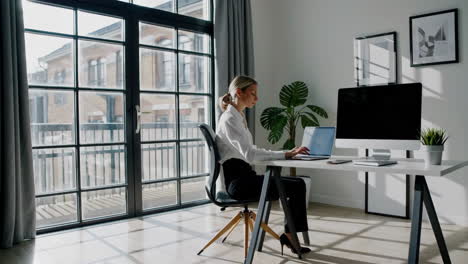 professional woman working on laptop in modern home office