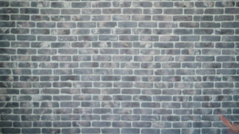 happy woman dancing in front of a brick wall