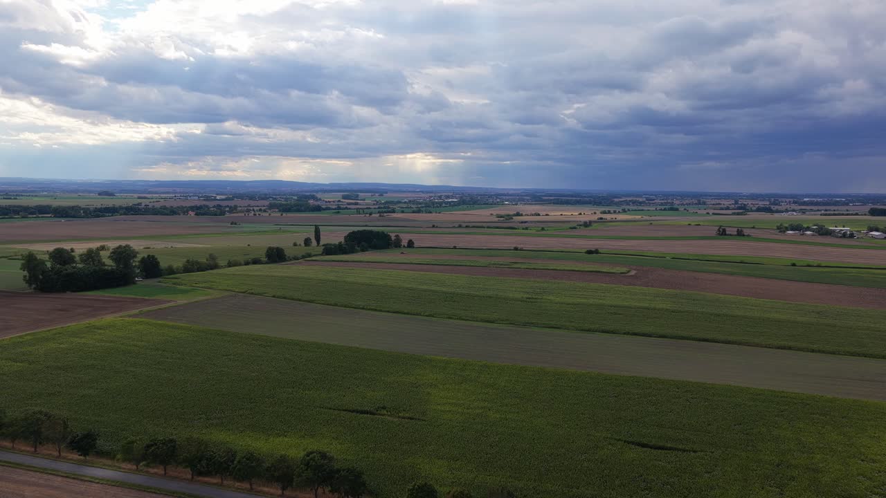 Czech landscape of fields and meadows from a drone view. Cloudy sky with clouds and villages in the distance