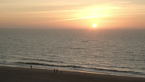 Gente-Caminando-Frente-A-La-Puesta-De-Sol-En-La-Playa-De-Sylt