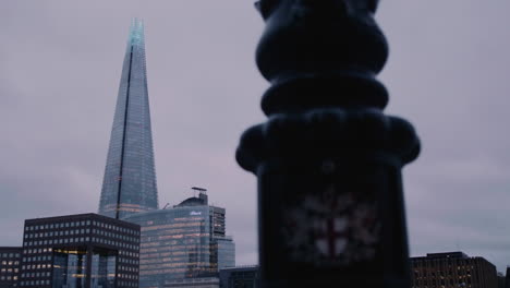 the emblem of the city of london on a lamppost and the shard in london