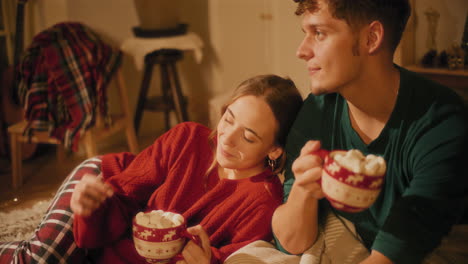 Woman-holding-cup-of-marsh-mellows-by-boyfriend