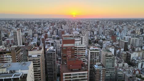 dolly in flying over belgrano neighborhood tall buildings at sunset, buenos aires, argentina