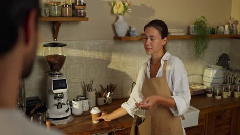 a barista serving a customer in a coffee shop