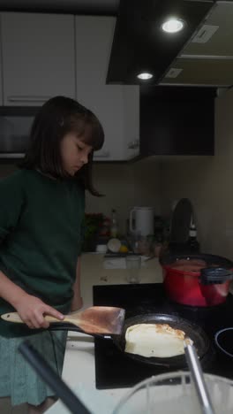little girl cooking pancakes