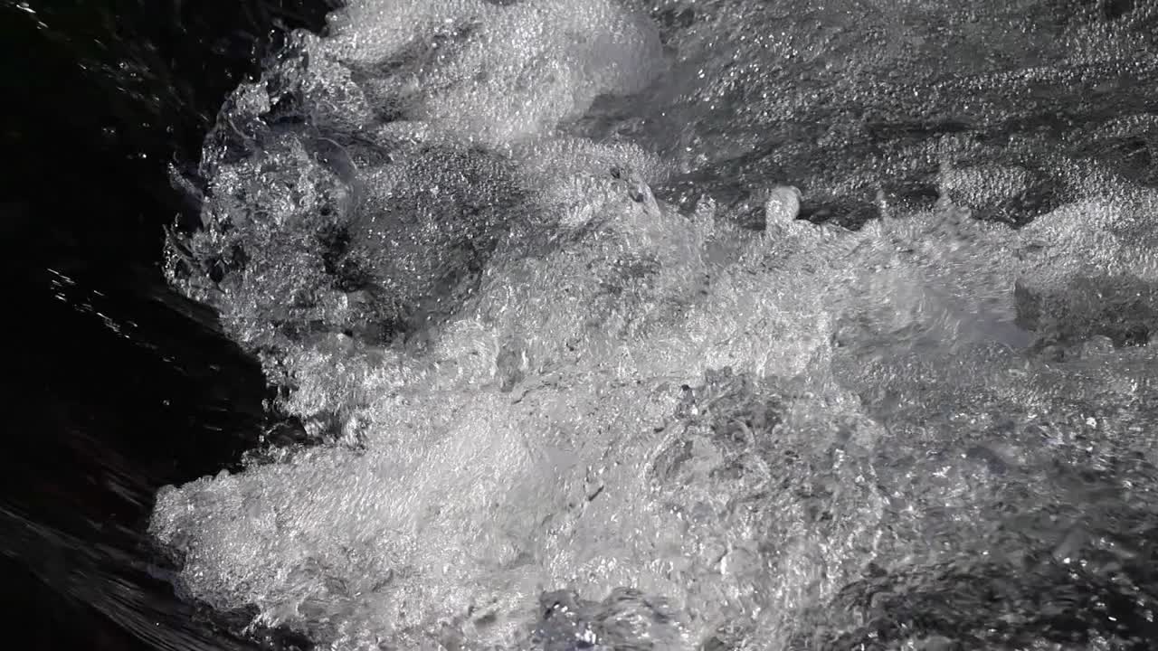 Water rushes down a small mini waterfall and accelerates the river.