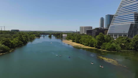 Disparo-De-Un-Dron-Inclinándose-Sobre-Kayaks-En-El-Río-Colorado-En-Un-Día-Soleado-En-Austin,-EE.UU.