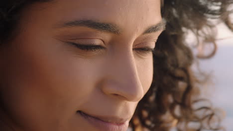 retrato en primer plano de una mujer hermosa y feliz disfrutando de la libertad explorando la espiritualidad sintiendo esperanza en la pacífica orilla del mar al atardecer con el pelo soplado por el viento