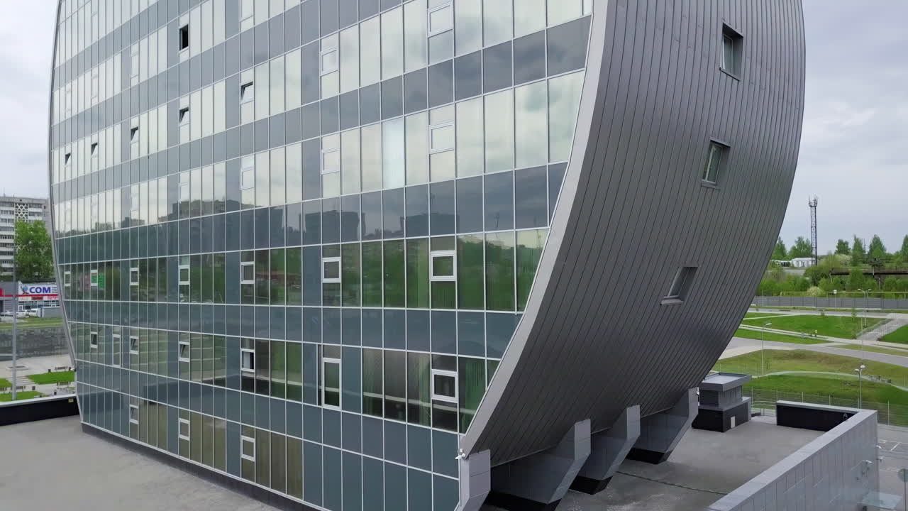 edificio de vidrio curvo en un entorno urbano