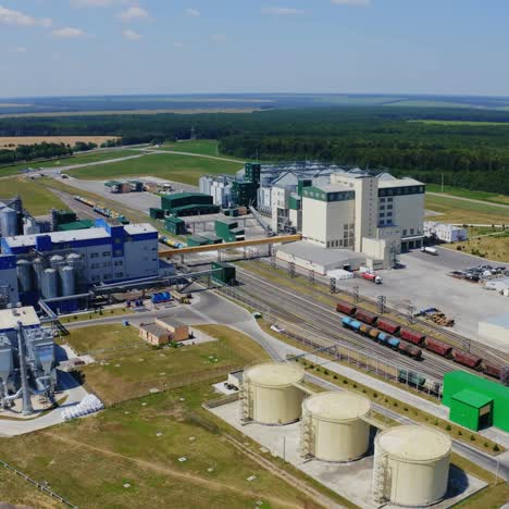 agriculture grain silos tanks on field. large territory of modern industrial plant with grain elevators among green nature. aerial view.