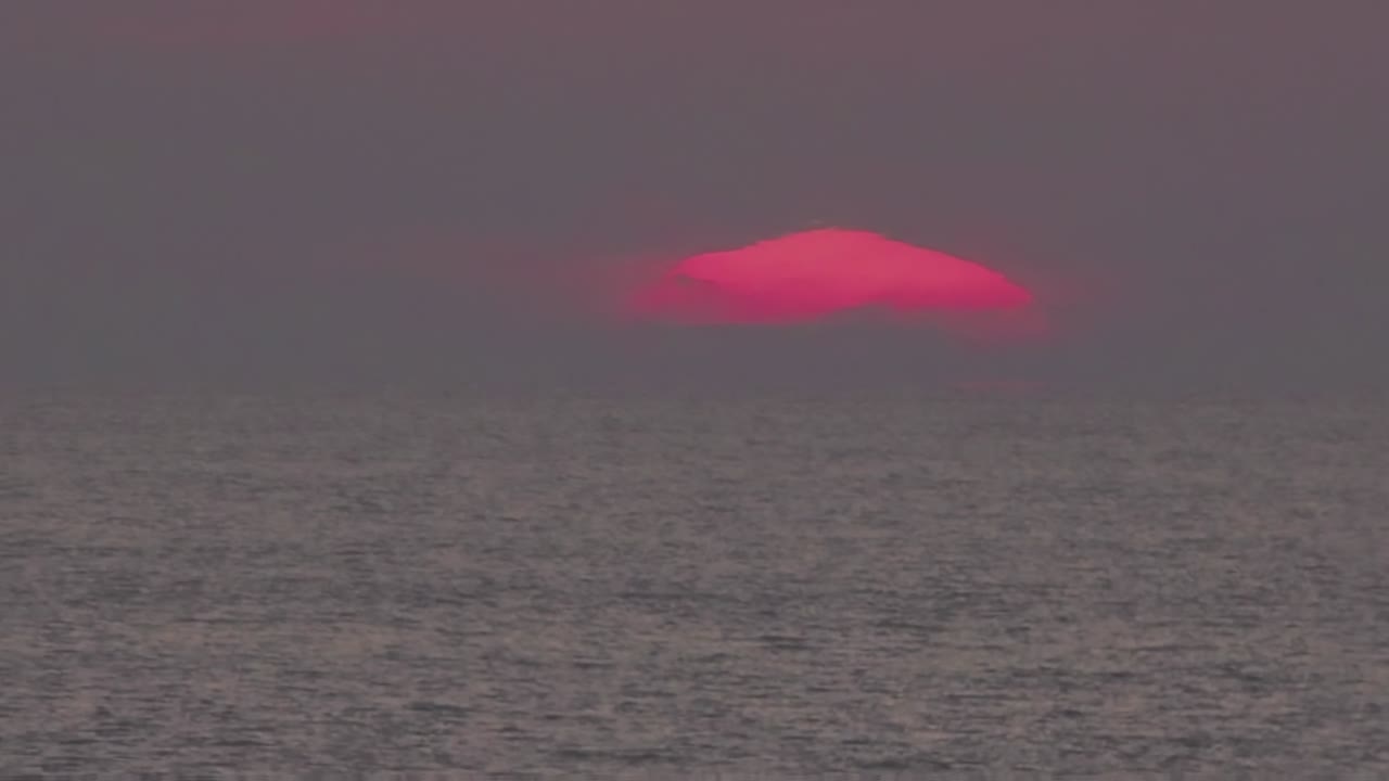 타임스, 큰 해가 파란색으로 변하는 오렌지색 구름 속에 가라앉습니다.