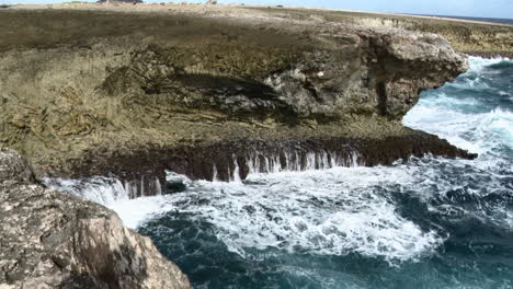 Olas-Rompiendo-En-Las-Rocas-En-Un-Pequeño-Agujero-De-Soplado,-Caribe,-Bonaire