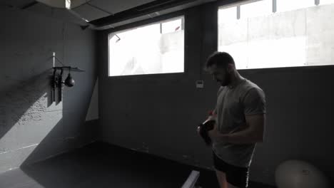 joven atlético haciendo ejercicio en el gimnasio en la máquina de remo